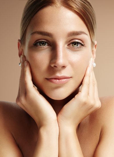 closeup portrait of a woman looking stright at camera and touching her face